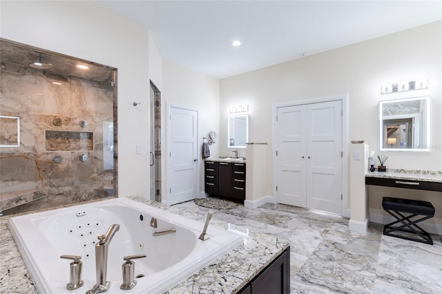 full bathroom featuring marble finish floor, a jetted tub, a shower stall, baseboards, and vanity