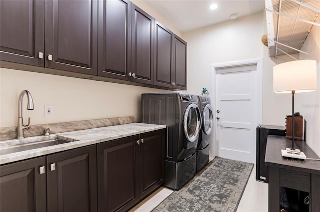 washroom featuring a sink, cabinet space, washing machine and dryer, and recessed lighting