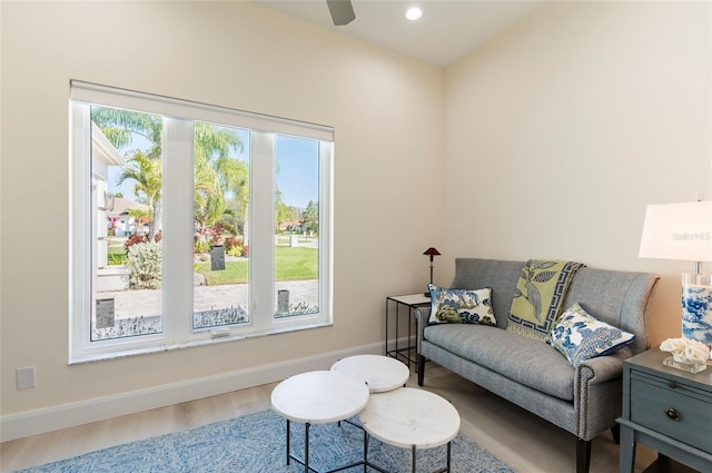 living room featuring plenty of natural light, baseboards, ceiling fan, and wood finished floors