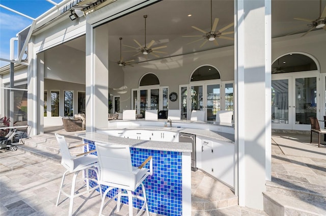 view of patio / terrace featuring outdoor dry bar, french doors, and a ceiling fan