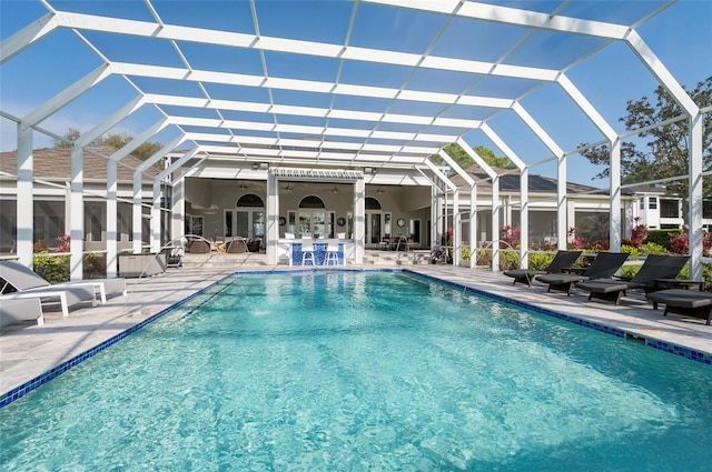 pool with a patio area and glass enclosure