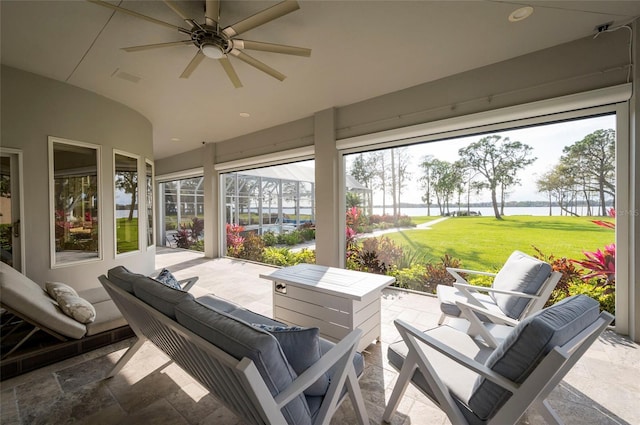 view of patio / terrace with glass enclosure, outdoor lounge area, ceiling fan, and a water view