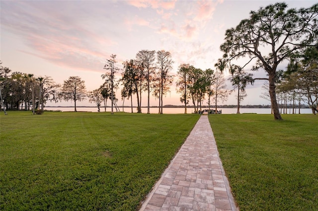 surrounding community with a yard and a water view