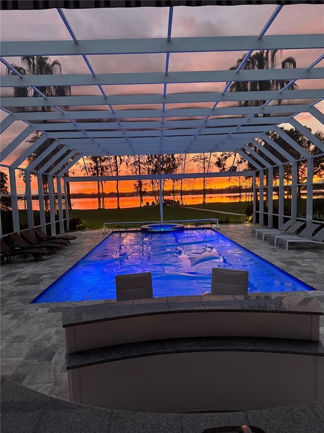 outdoor pool with an in ground hot tub, a lanai, and a patio area