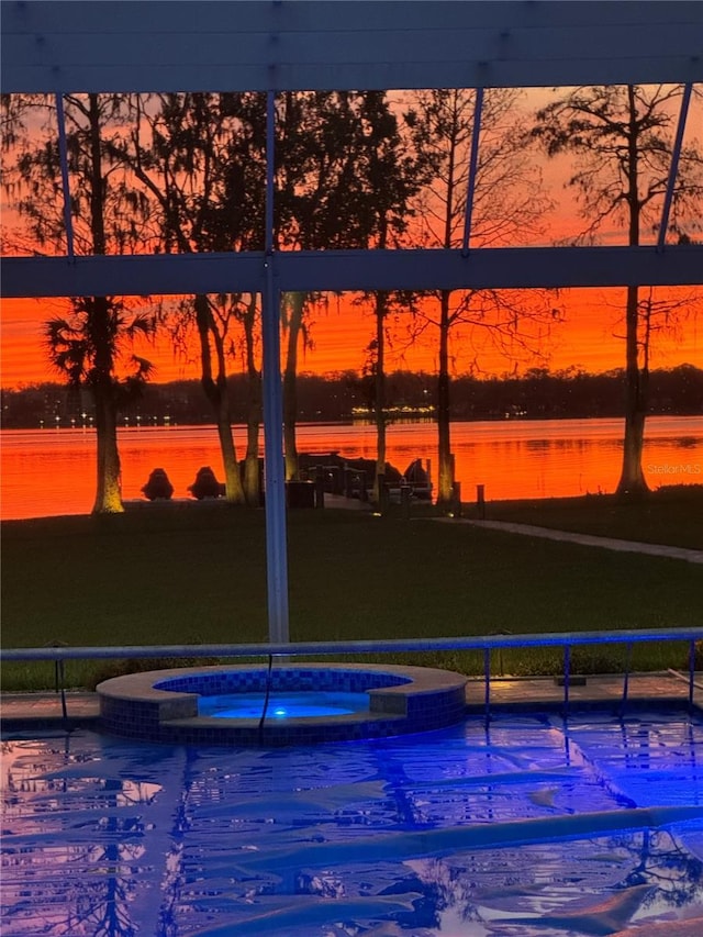 exterior space featuring a water view and a pool with connected hot tub