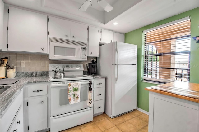 kitchen featuring white appliances, light tile patterned floors, decorative backsplash, light countertops, and white cabinets