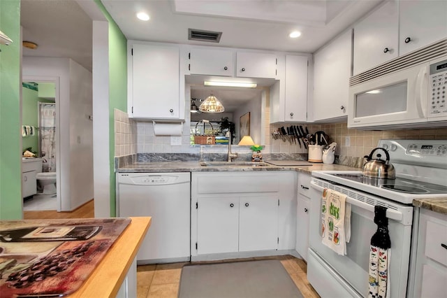 kitchen featuring visible vents, a sink, backsplash, white appliances, and white cabinets