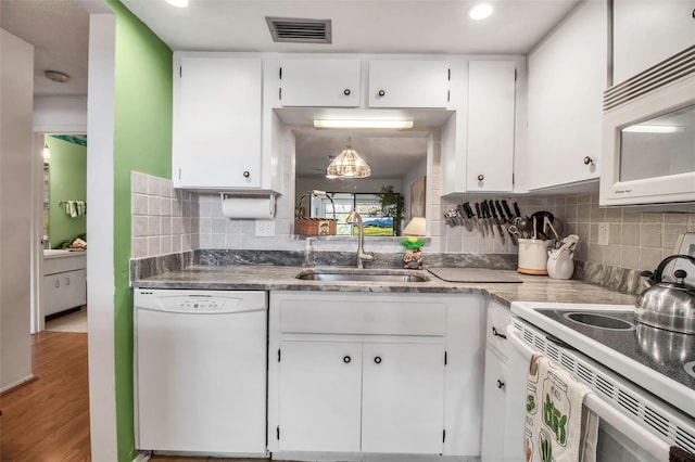 kitchen featuring visible vents, light wood-type flooring, white cabinets, white appliances, and a sink