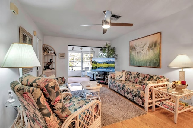 living area with a ceiling fan and wood finished floors