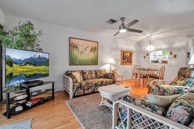 living area featuring visible vents, ceiling fan, and light wood finished floors