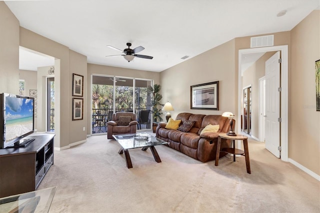 living area featuring visible vents, light colored carpet, a ceiling fan, and baseboards