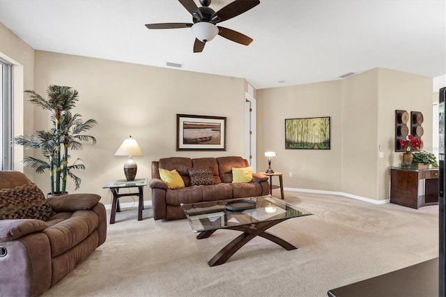 living room featuring a ceiling fan, baseboards, visible vents, and light carpet