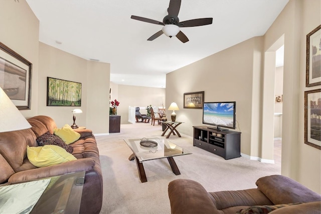 living area featuring ceiling fan, baseboards, and carpet floors