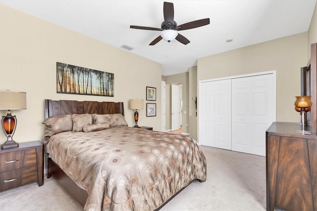 bedroom with ceiling fan, visible vents, a closet, and light carpet