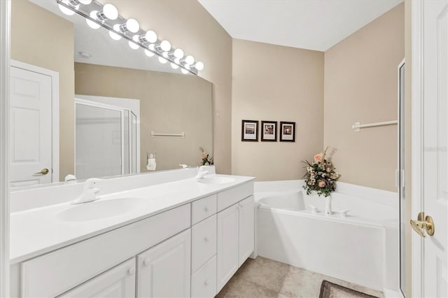 bathroom with tile patterned flooring, a shower stall, a garden tub, and a sink