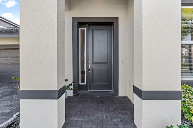 doorway to property featuring stucco siding