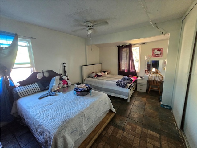 bedroom featuring a textured ceiling and a ceiling fan