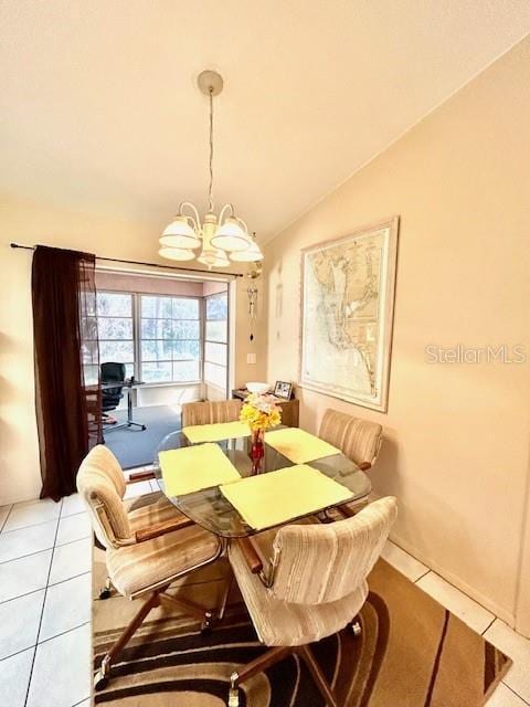 dining room with lofted ceiling, light tile patterned floors, and an inviting chandelier