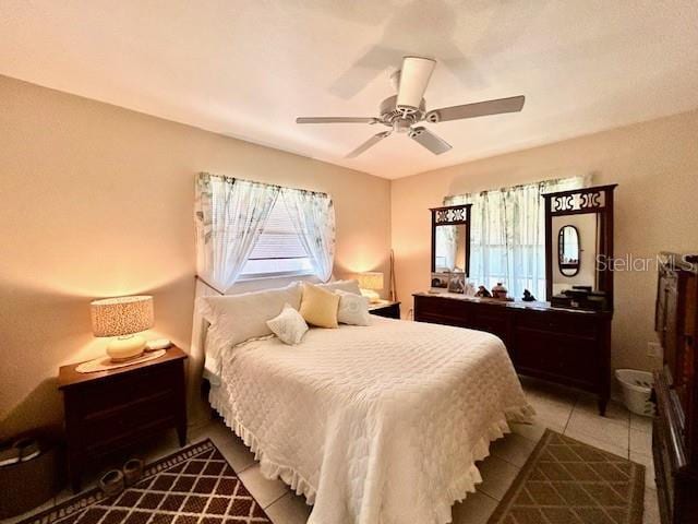 tiled bedroom with a ceiling fan