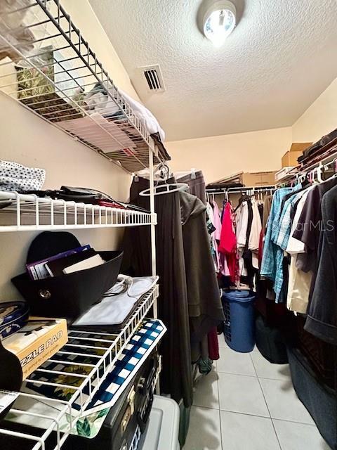 walk in closet featuring tile patterned flooring and visible vents