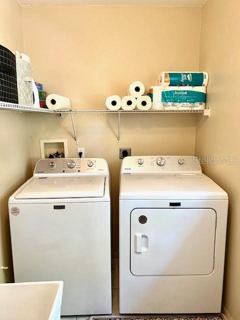 laundry room with laundry area, independent washer and dryer, and a sink