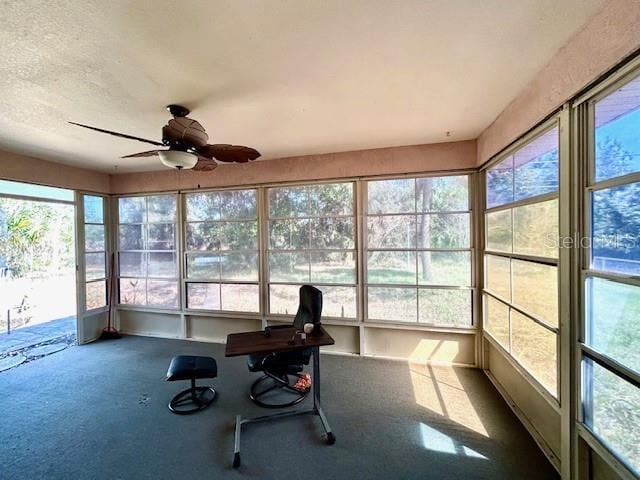 unfurnished sunroom featuring ceiling fan