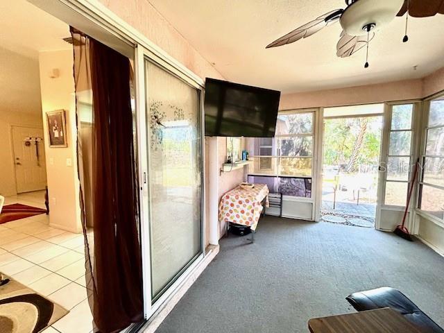 unfurnished sunroom featuring ceiling fan