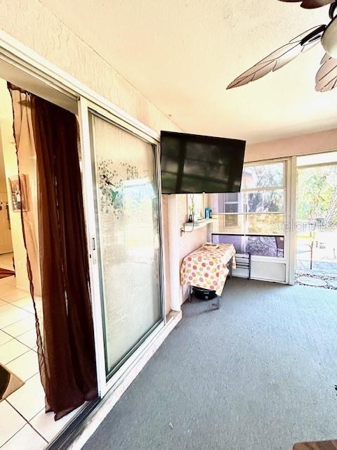 unfurnished sunroom with a ceiling fan