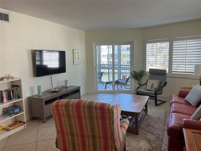 living area featuring light tile patterned floors, visible vents, and baseboards