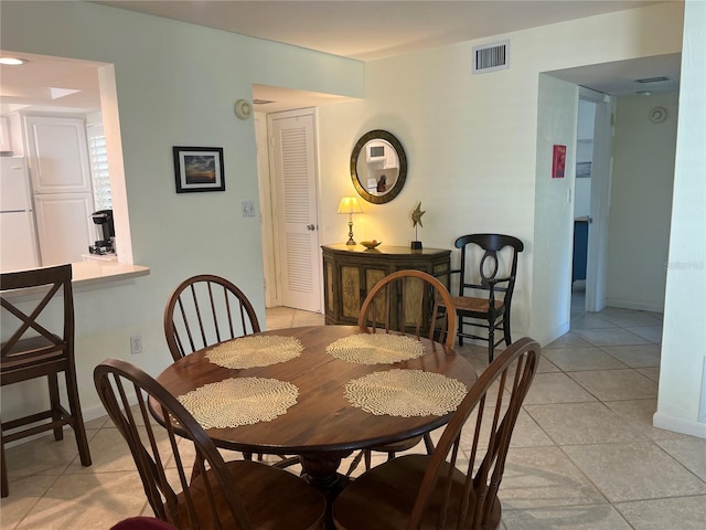 dining area with light tile patterned floors, visible vents, and baseboards