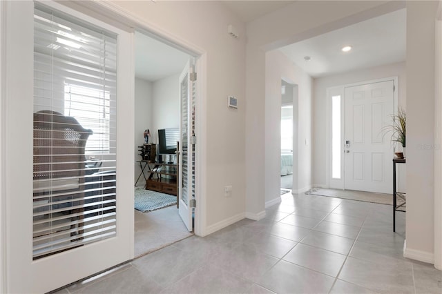 tiled entryway featuring recessed lighting and baseboards