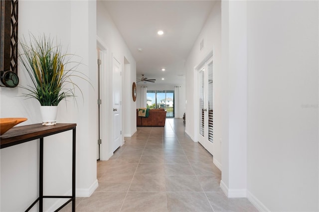 hall with light tile patterned floors, baseboards, and recessed lighting