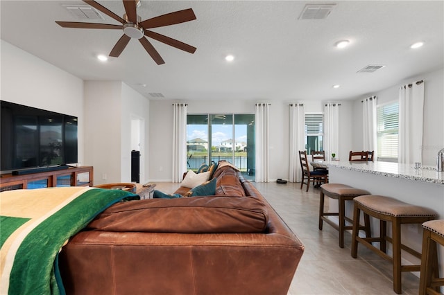 living room featuring light tile patterned floors, visible vents, and recessed lighting