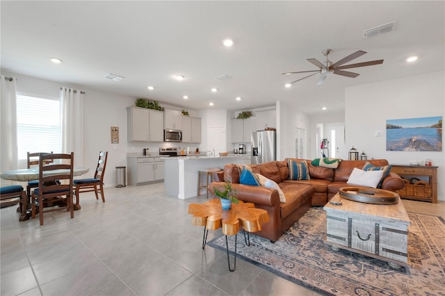 living room featuring a ceiling fan, light tile patterned floors, recessed lighting, and visible vents