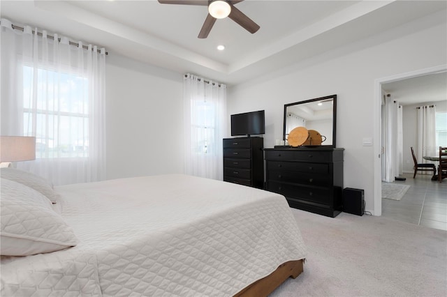 carpeted bedroom with a ceiling fan, a raised ceiling, and recessed lighting