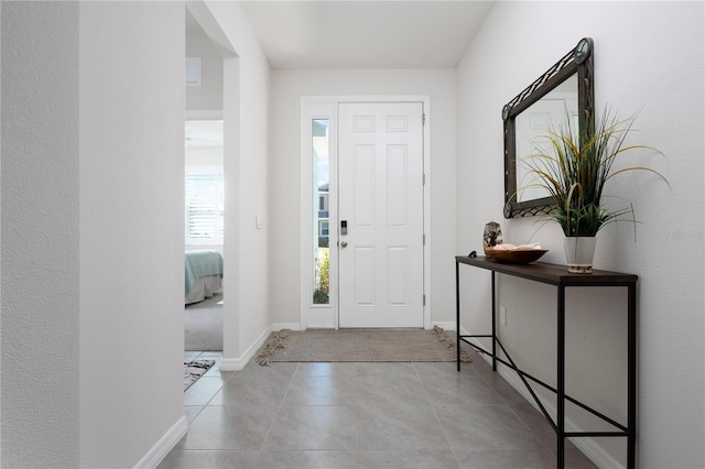 tiled foyer entrance with baseboards