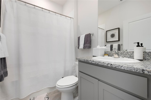 bathroom featuring tile patterned flooring, toilet, and vanity