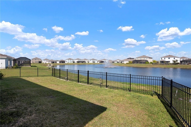 view of yard with a residential view, fence, and a water view