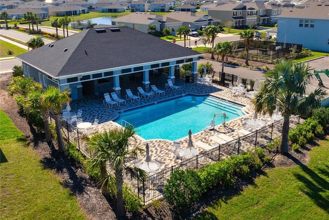 community pool featuring a residential view, a patio, and fence