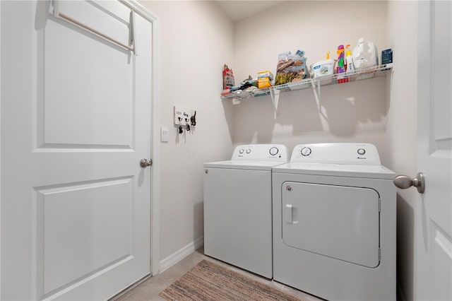 washroom with laundry area, independent washer and dryer, and baseboards