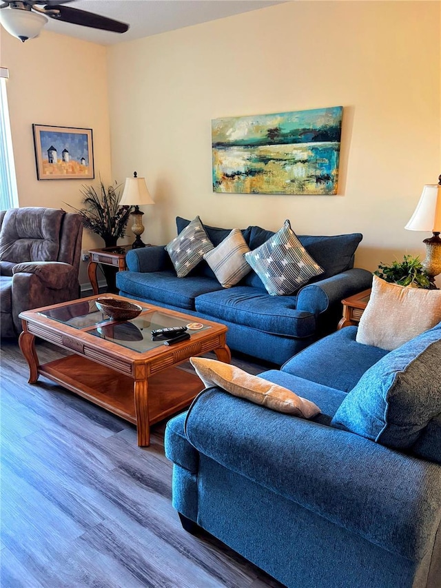 living area with a ceiling fan and wood finished floors