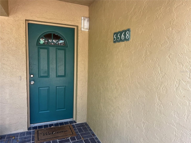 view of exterior entry featuring stucco siding