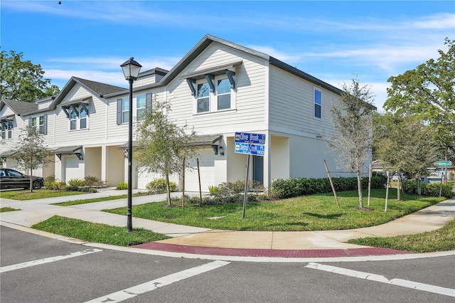 multi unit property with a front lawn, a garage, driveway, and stucco siding