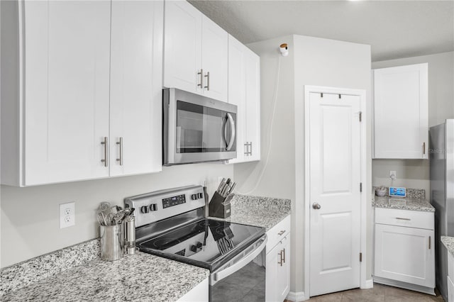 kitchen featuring white cabinetry, light stone countertops, and stainless steel appliances