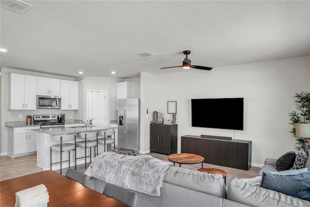 living area with recessed lighting, visible vents, and baseboards