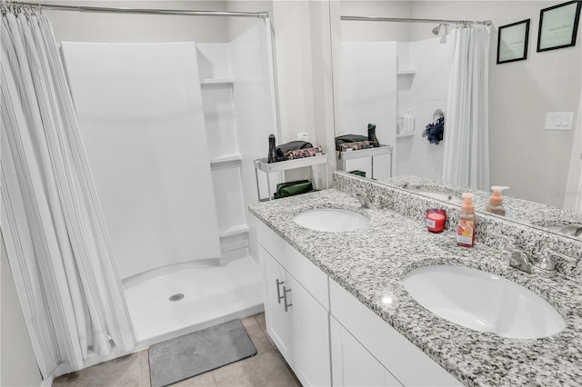 full bathroom featuring a sink, double vanity, a stall shower, and tile patterned floors