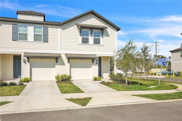 townhome / multi-family property featuring stucco siding, driveway, and a garage