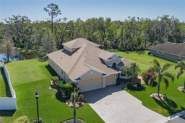 birds eye view of property featuring a forest view and a water view