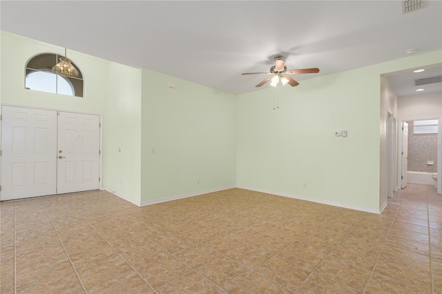 interior space featuring visible vents, baseboards, ceiling fan, and light tile patterned flooring