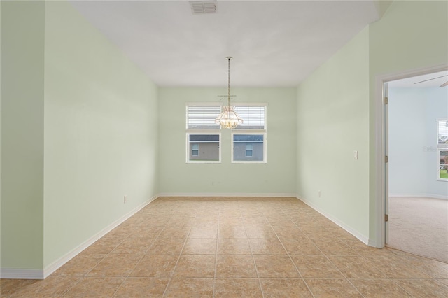 spare room with a chandelier, visible vents, baseboards, and light tile patterned floors